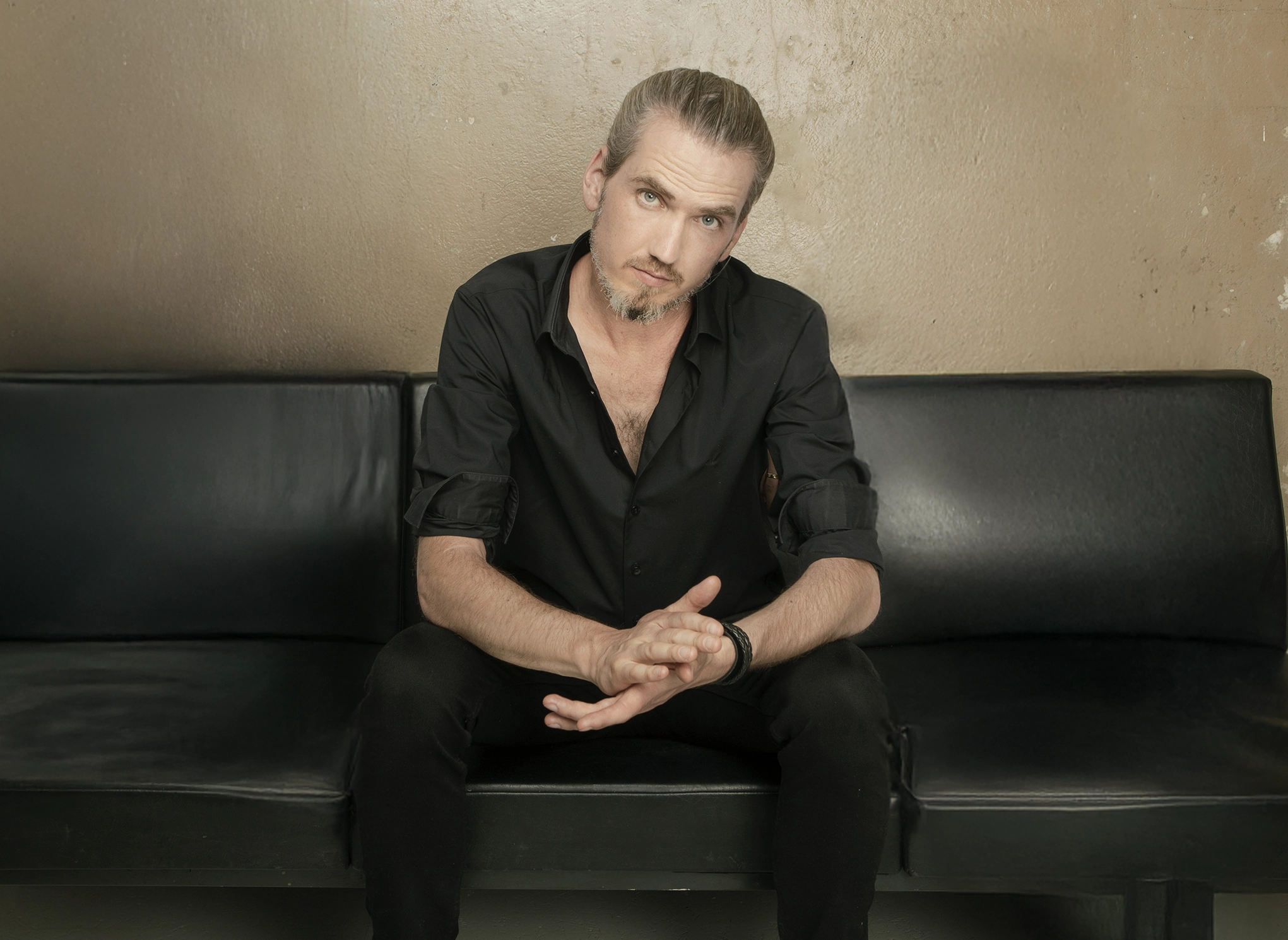 Tobias Leon seated on a leather sofa